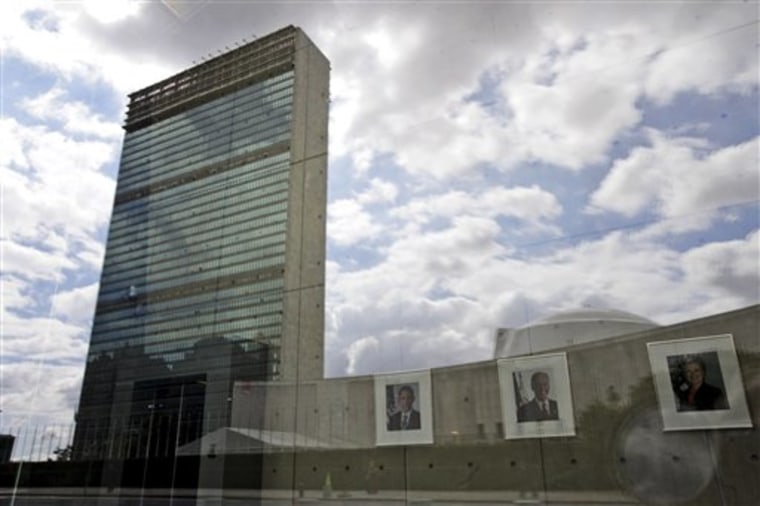 The United Nations building in New York City is reflected on the window of the U.S. mission to the U.N. as portraits of American President Barack Obama, left, Vice President Joe Biden, and Secretary of State Hillary Clinton hang in the lobby. 
